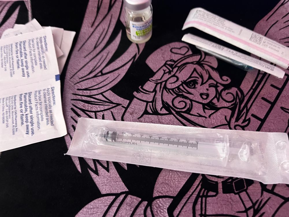 Photo of injection supplies staged on Pvramid’s Injection Fairy Lily cloth with black fabric and metallic pink inking 