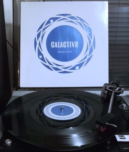 Vinyl record Waterfall / Passion by Re:Locate playing next to its sleeve.