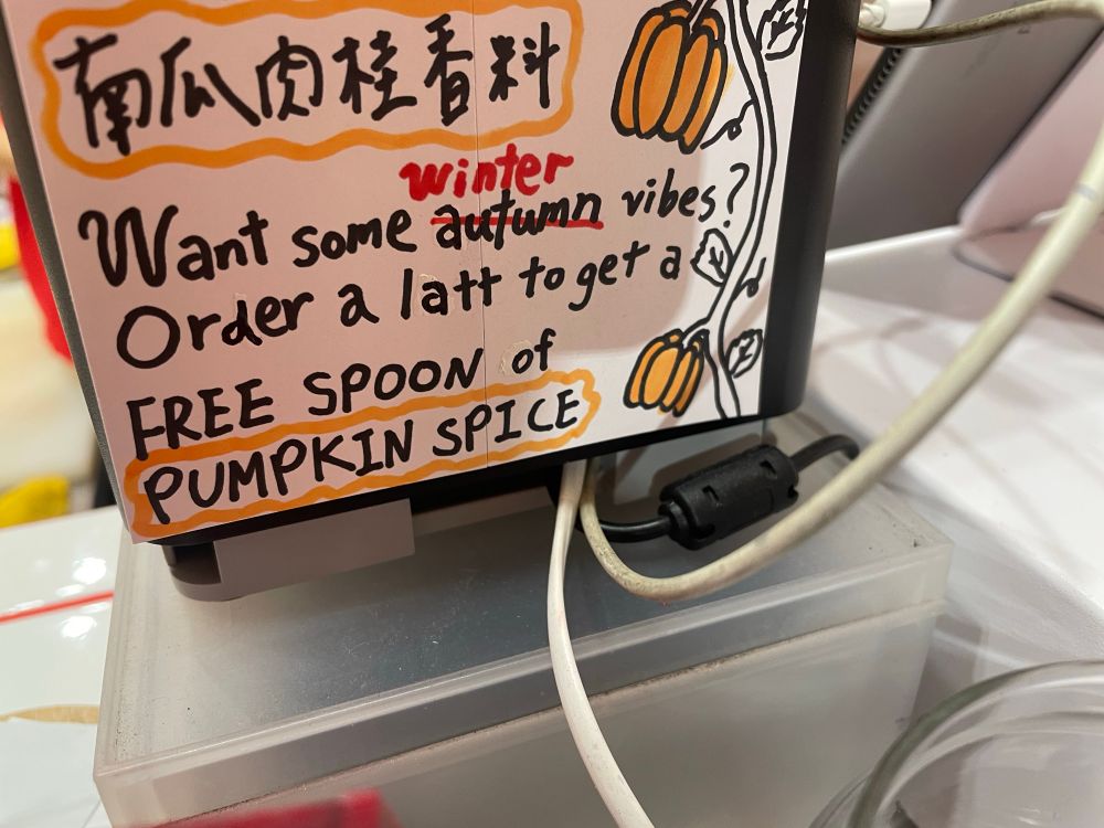 A sign in a restaurant saying “Order a latte to get a FREE SPOON of PUMPKIN SPICE”
