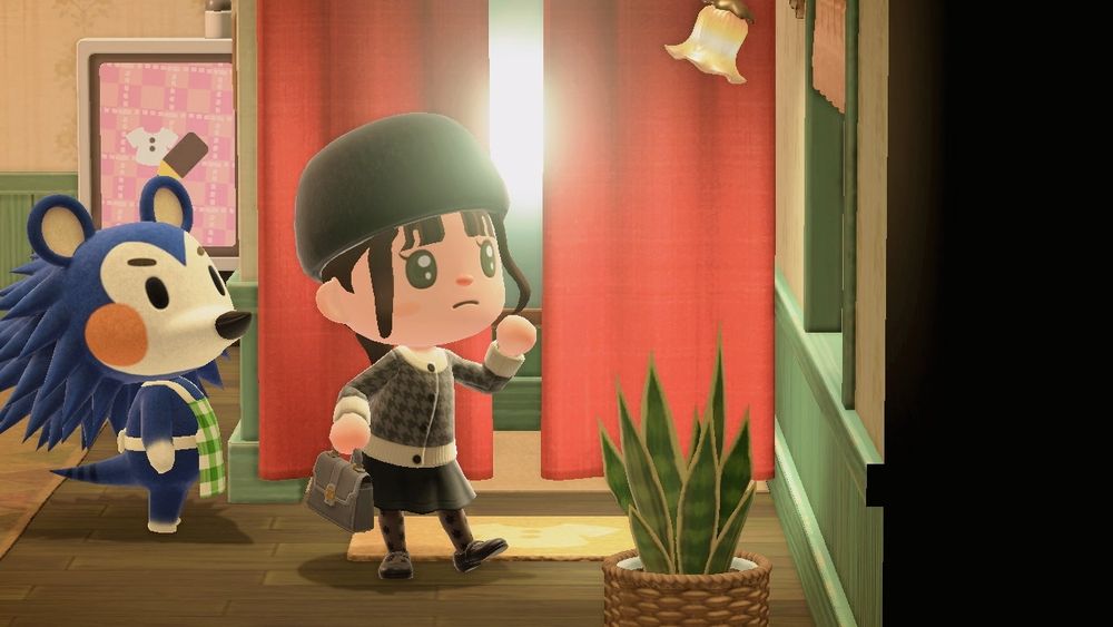 스위치 게임 동물의 숲 스크린샷. 빨간 커튼과 조명이 달린 탈의실의 입구 앞에서 검은 털모자, 검은 타탄체크 니트 가디건, 검은 플레어 스커트, 투명한 검은 꽃무늬 스타킹, 애나멜 구두를 신고 멋진 자세를 취하고 있는 몬나의 주민 대표. 갈색 머리카락에 녹색 초롱는이다. 고순이는 옆으로 선 채 그 모습을 지켜본다.