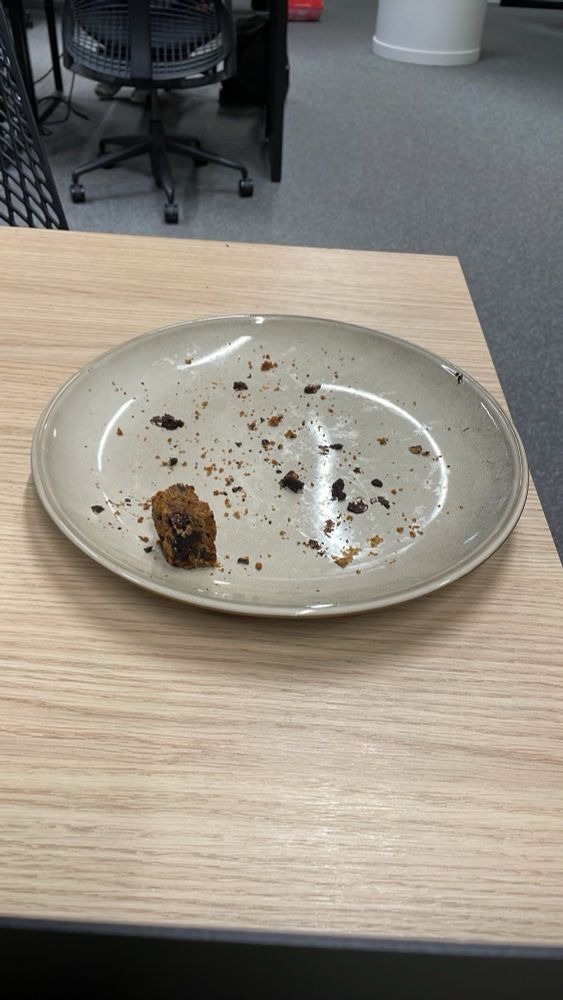 Nearly empty plate with crumbs and one brownie