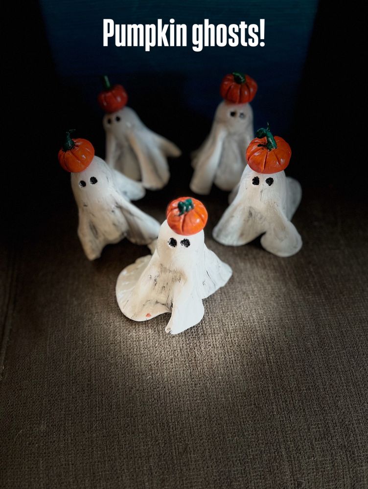 Five tiny ghost figurines with pumpkins on their heads. 