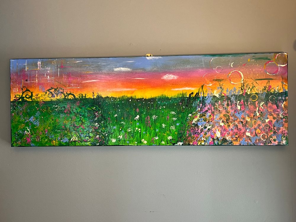 A long painting featuring a garden at sunset in the middle, exploding into nothing but colors in different styles at either end. 