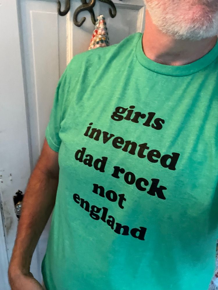Me wearing a T-shirt that says, “Girls invented Dad rock not England.”