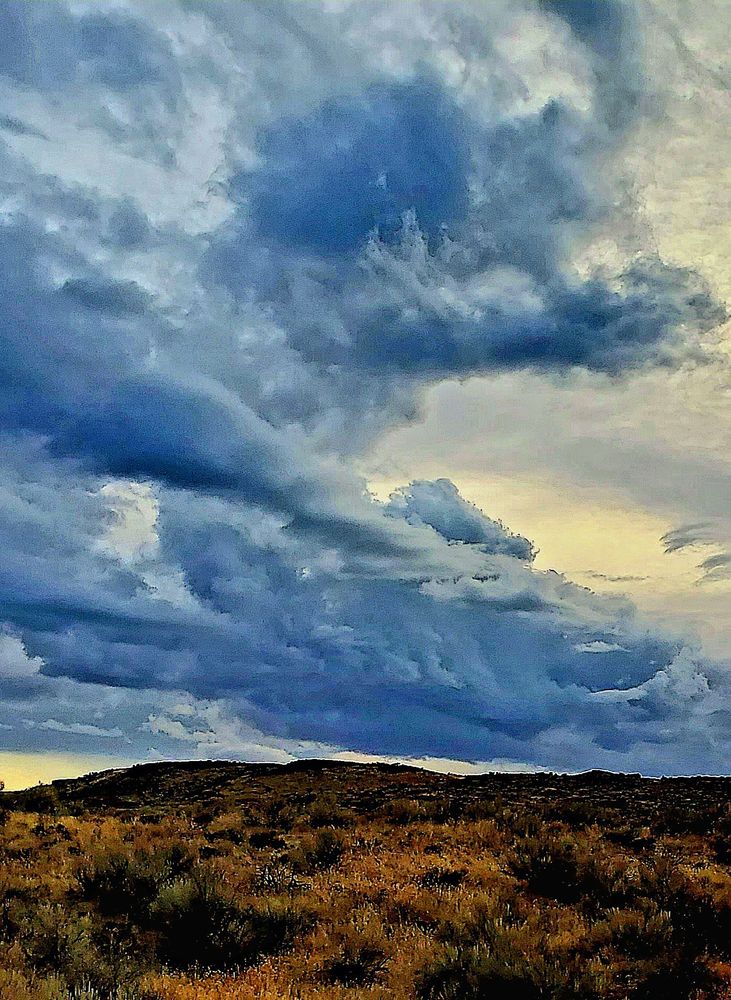 A storm is rolling across a high desert ridge