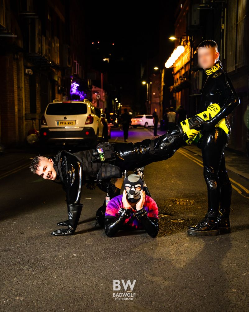 2 rubber human dogs doing a wheelbarrow while a third one is posing all cute underneath