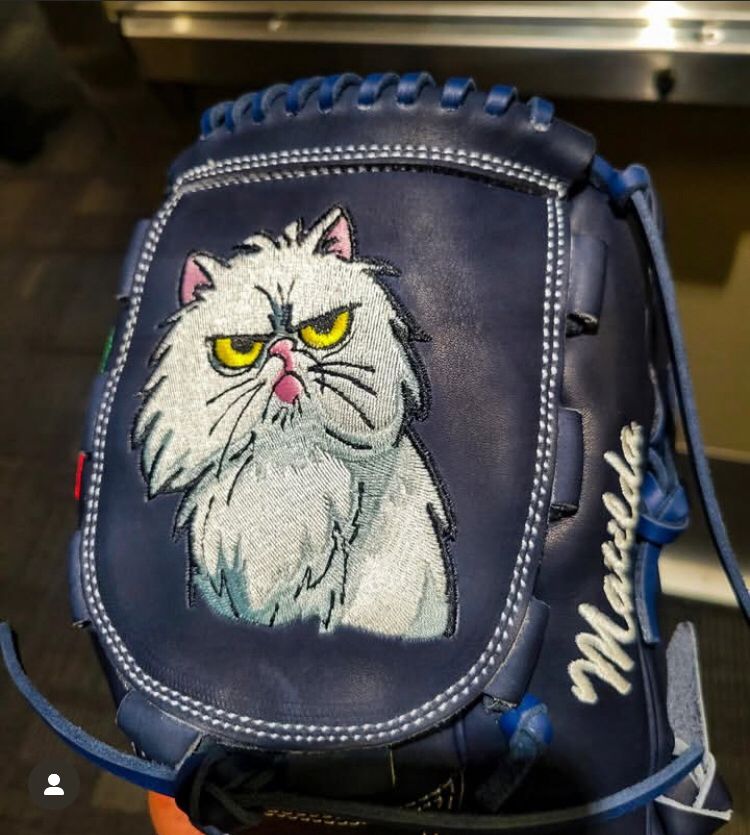 Andrés Muñoz’s baseball glove. It’s a dark navy leather with a large white fluffy cat stitched on. Matilda, the white cat has resting bitch face and looks appropriately angry on the glove. “Matilda” is written in white on the side of the glove in cursive.