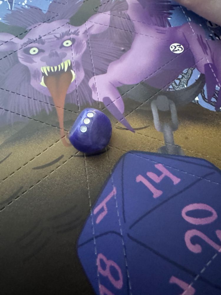 A three sided rolling die on a print of Krampus