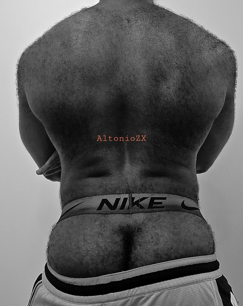 AltonioZX with his hairy back facing the camera, ass peaking over his basketball shorts in a Nike jockstrap 
