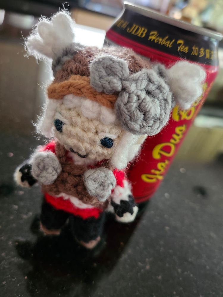 crochet doll propped up against a can