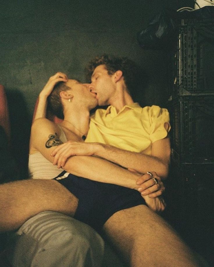 A man sitting in another’s lap embracing and making out