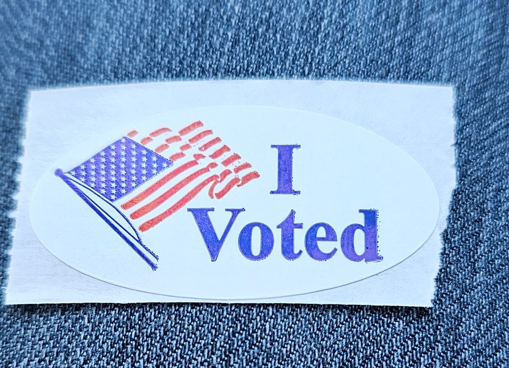 An I VOTED sticker on a pair of blue jeans.