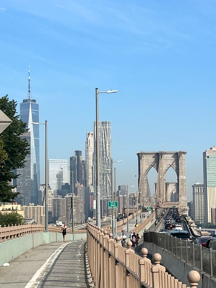 A picture of the pedestrian pathway leading up to the Brooklyn Bridge, taken from the Brooklyn side of the East river.