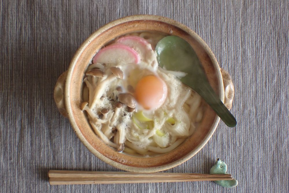 冷凍かまぼこ、白ねぎ、しめじ、たまご入りの鍋焼きうどん