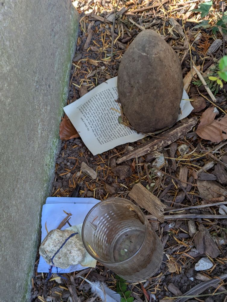 Pages of the short story The Library of Babel under a rock at Borges' grave.