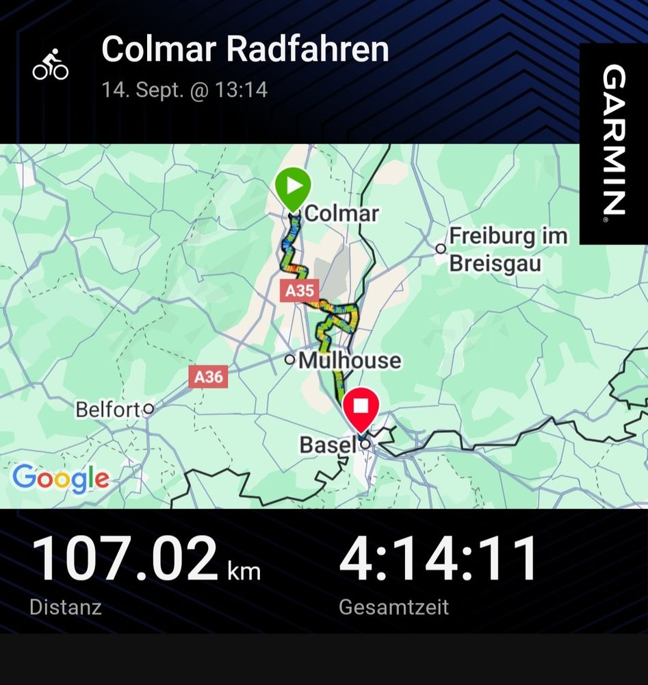 Das Bild zeigt die Aufzeichnung einer Fahrradtour auf der Garmin-App. Oben steht der Titel "Colmar Radfahren" mit dem Datum und der Uhrzeit, 14. Sept. @ 13:14.
In der Mitte des Bildes ist eine Landkarte zu sehen. Darauf sind der Startpunkt in Colmar (grünes Symbol), der Endpunkt in der Nähe von Basel (rotes Symbol) und die zurückgelegte Strecke als bunte Linie eingezeichnet. Außerdem sind auf der Karte die Städte Mulhouse, Freiburg im Breisgau und Belfort sowie die Autobahnen A35 und A36 markiert.
Am unteren Rand des Bildes werden die wichtigsten Daten der Tour angezeigt:
 * 107.02 km als "Distanz"
 * 4:14:11 als "Gesamtzeit"
