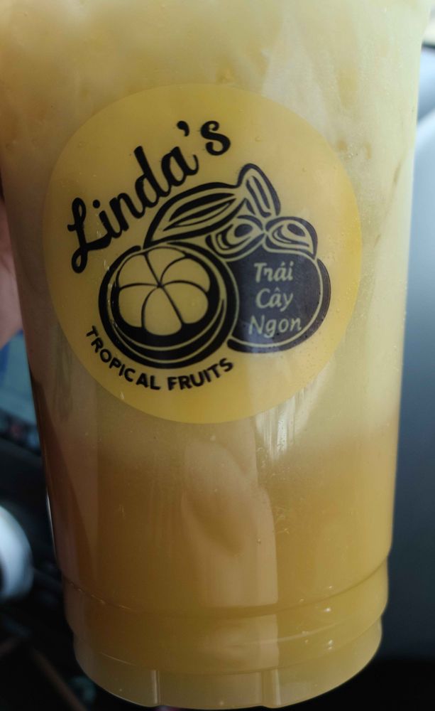 Linda's Tropical Fruit - Trái Cây Ngon -- close up of a fresh durian and cane juice iced drink. It's a creamy yellow-green with ice and durian floating along the top.
