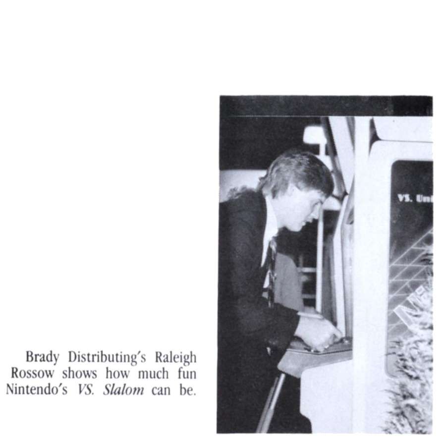 from a 1986 coin-op trade magazine, a black and white photo of a side view of a man playing an arcade game, the caption says Brady Distributing's Raleigh Rossow shows how much fun Nintendo's VS. Slalom can be.