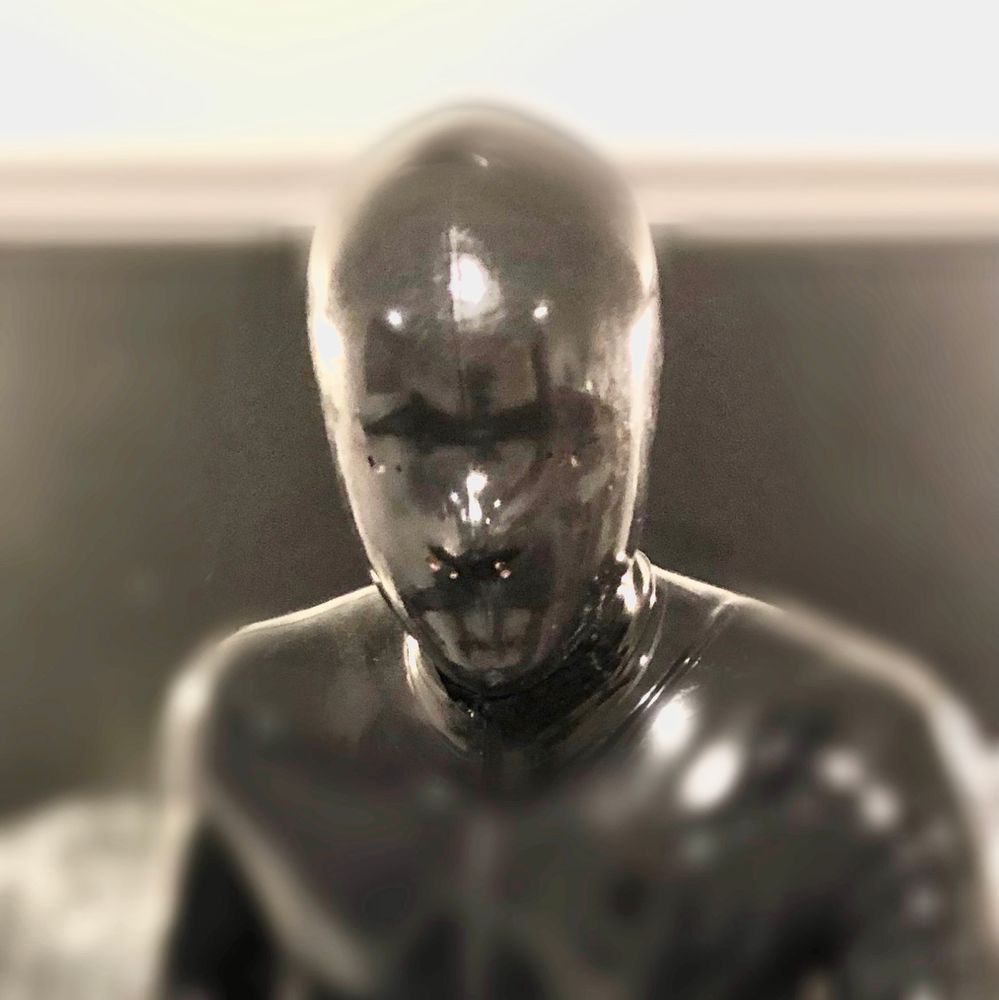 A man in a tight fitting black rubber mask. 