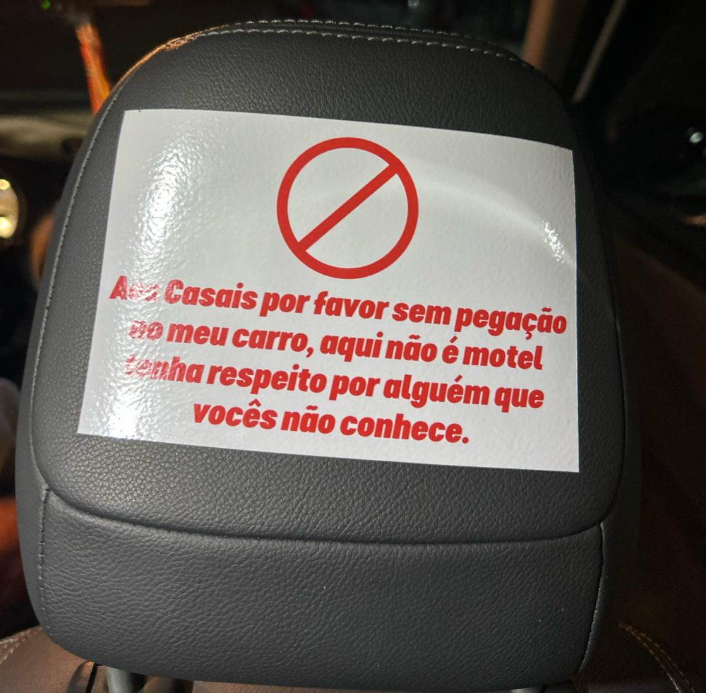 placa num carro que diz, "Aos Casais por favor sem pegação meu carro, aqui não é motel tenha respeito por alguém que vocês não conhece."