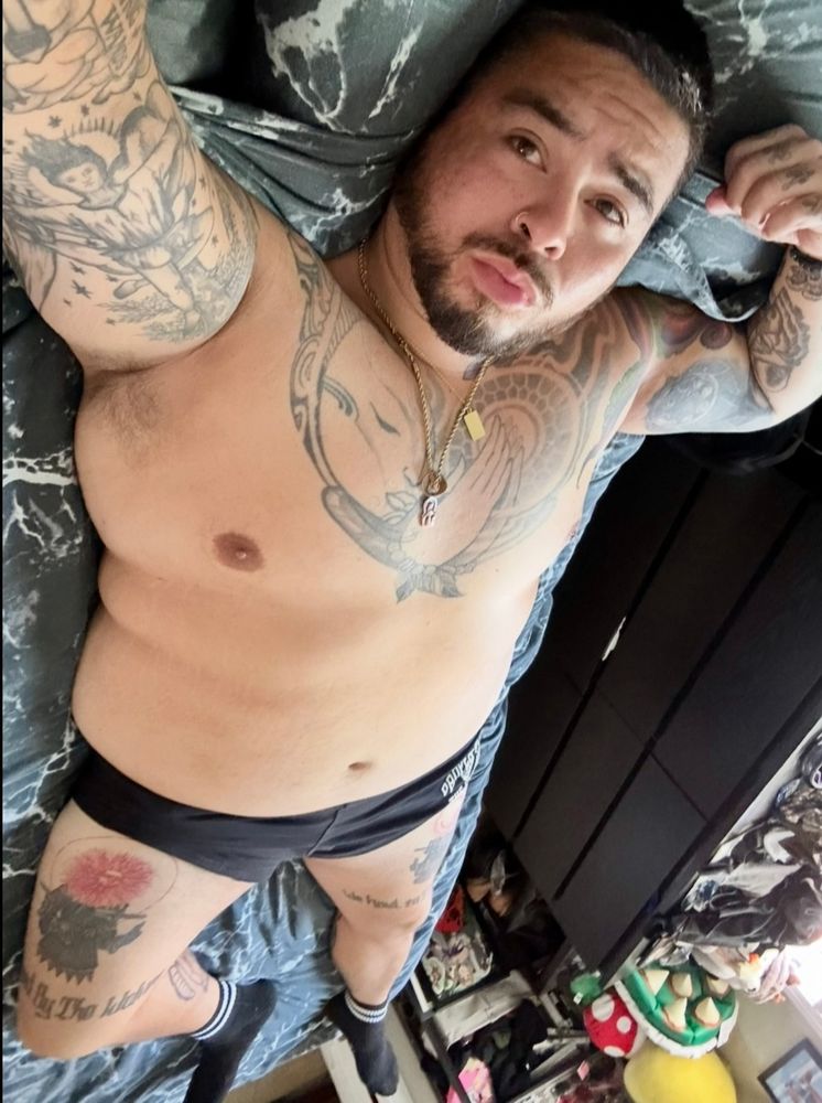 Me, a chubby dude, laying on my bed 
