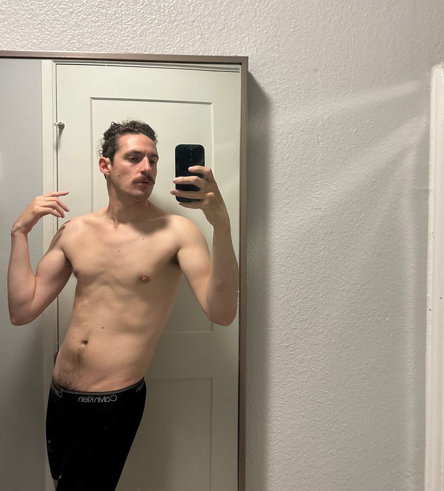 Cutie stands in the mirror with black briefs and and a treasure trail peeking out