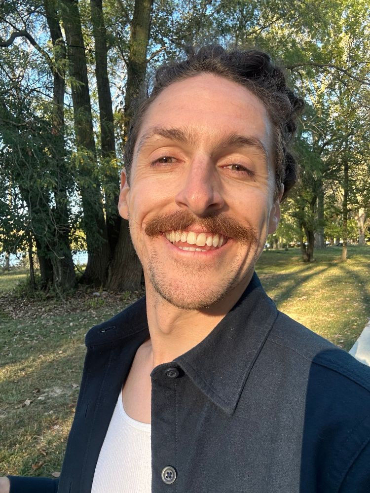 Mustachioed cutie smiling big for golden hour