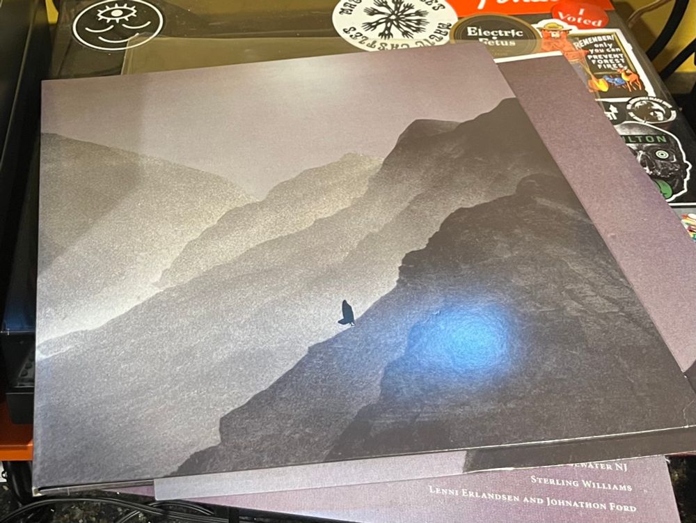 LP Album jacket sitting on top of a turntable dust cover 