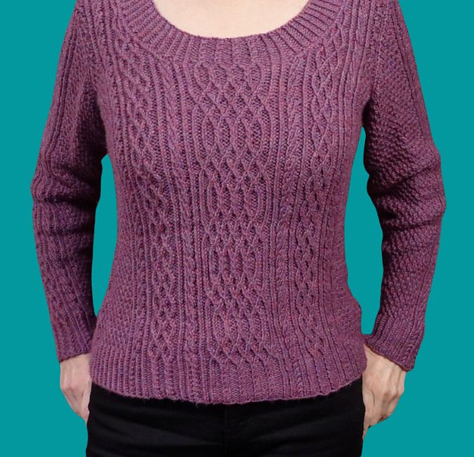 A close fitting sweater in a dusky raspberry pink with a scooped neck has panels of traveling twisted stitch patterns, some of which extend into the ribbings.
