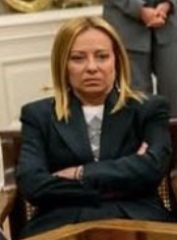 Meloni with arms crossed and scowling. 