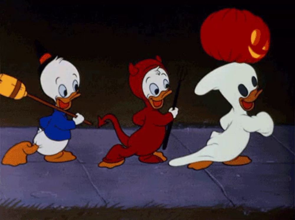 three cartoon ducks dressed in halloween costumes are walking down a sidewalk