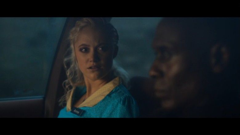 Maika Monroe and Lance Reddick driving in a car while he tells her the terrible truth about David (The Guest, 2014)