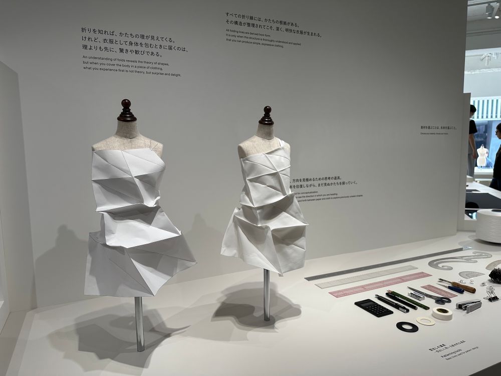2体のトルソーに着せられた2つの白いドレス。折り紙のような直線的な折り目を生かしたデザイン。