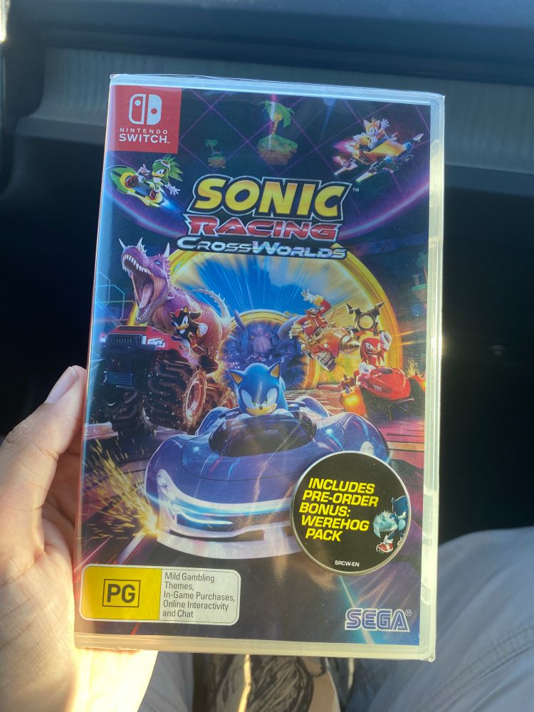 Picture of my holding sonic racing crossworlds with preorder bonus sticker