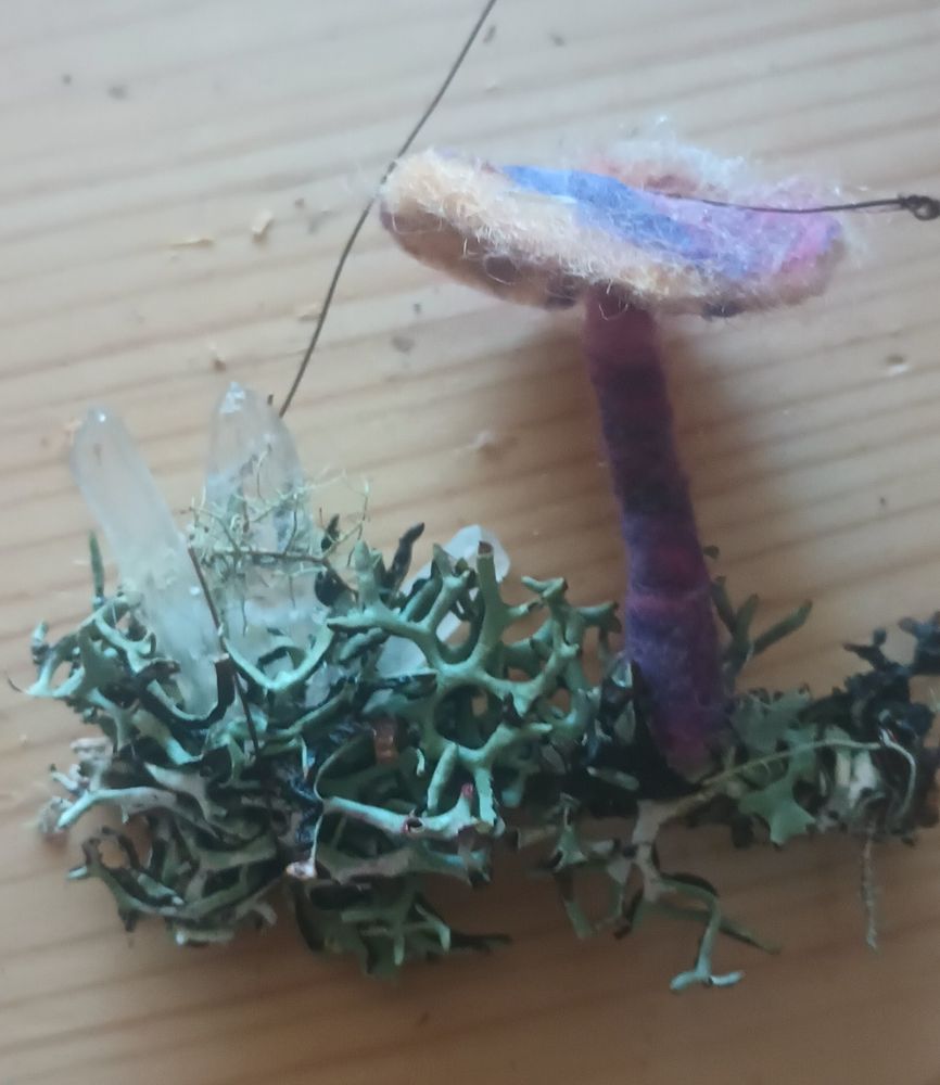 A needle felted mushrooms, with natural moss and crystals