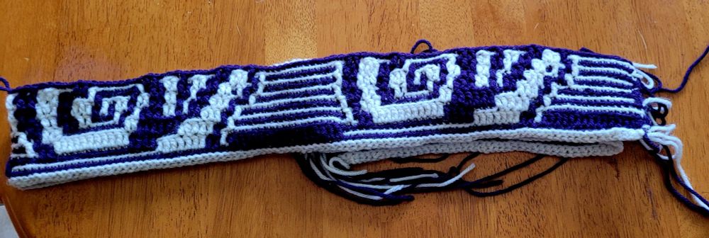 a strip of mosaic crochet showing an emerging snail pattern