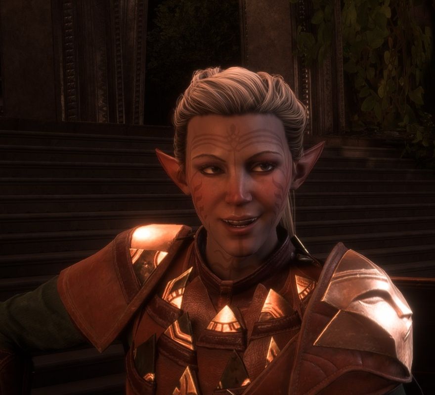 Elven Rook in a Dragon Age: The Veilguard cutscene. She is smiling at a character out of frame. She wears a leather outfit with triangular metal shapes and a metal shoulder-pad with an abstract face. In the background, there are stairs and arches of stone.