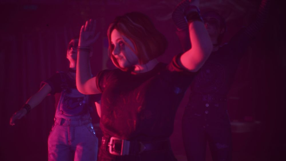 Three girls dance in pink lighting 