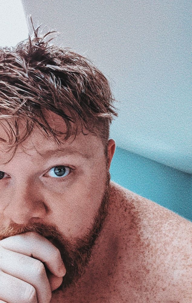 A selfie, shirtless with freckles and post shower wet hair. 