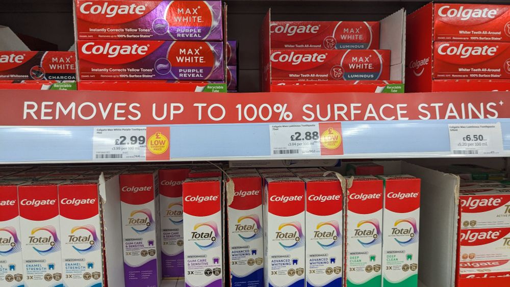 Advertising banner on toothpaste saying "removes up to 100% stains"