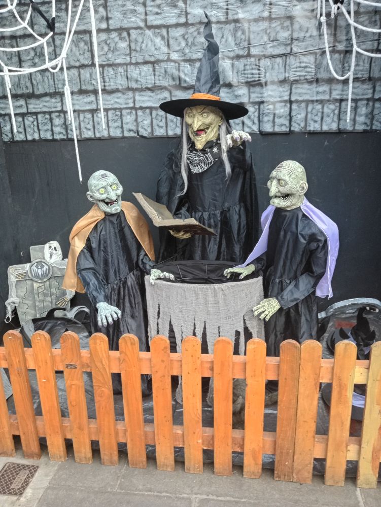 Spooky Tableau, a witch and helpers attend to a cauldren