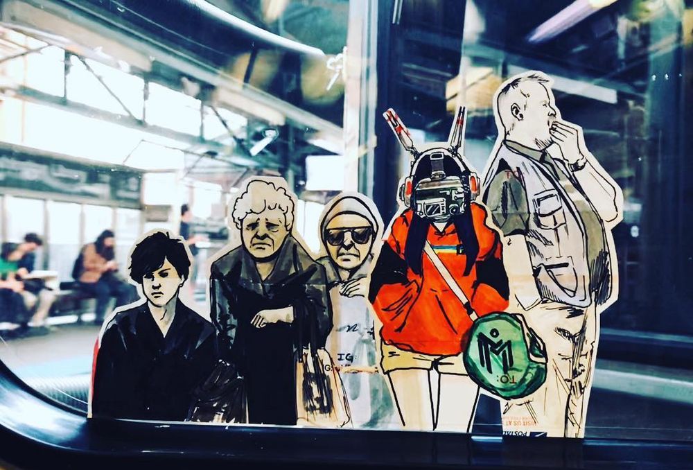 Sticker placed in forced perspective to show a group of people waiting for transit. 