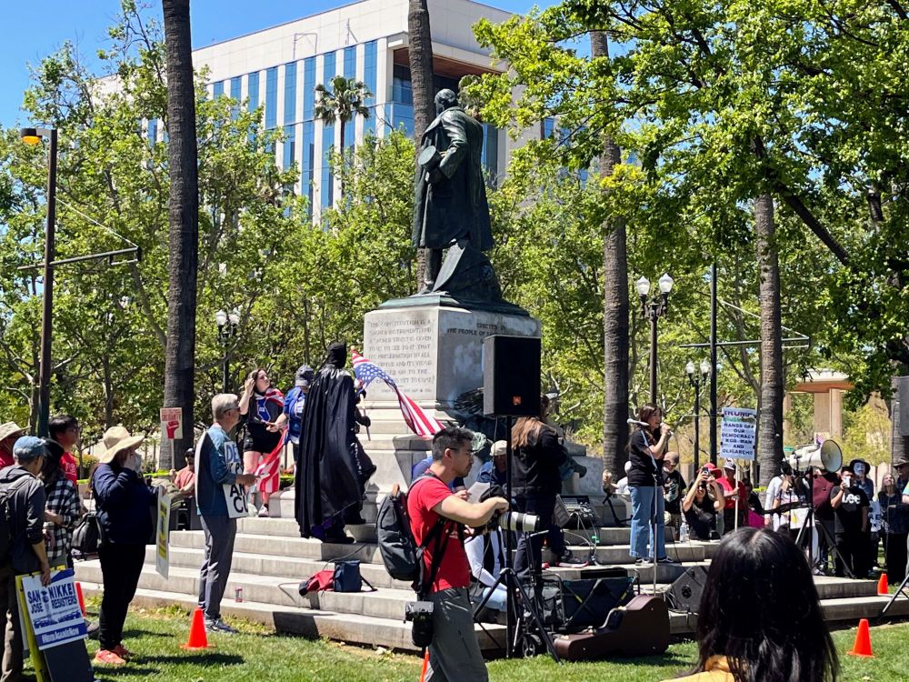 Betty Duong speaking under the McKinley statue in St. James Park