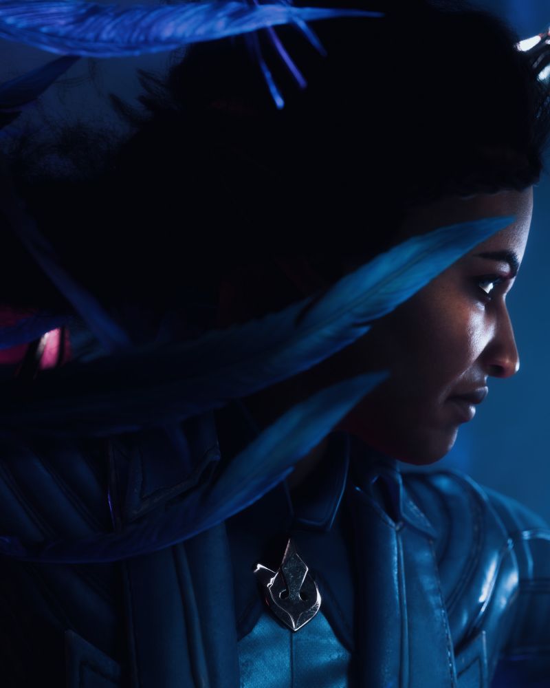 Zea De Riva (Rook) with blue feathers in front of face