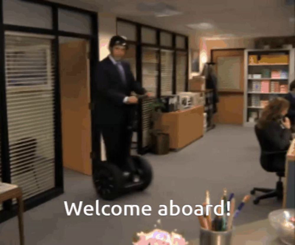 a man is riding a segway in an office with the words welcome aboard below him