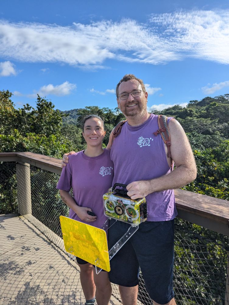 Two folks grabbing q science sensor on canopy tower 
