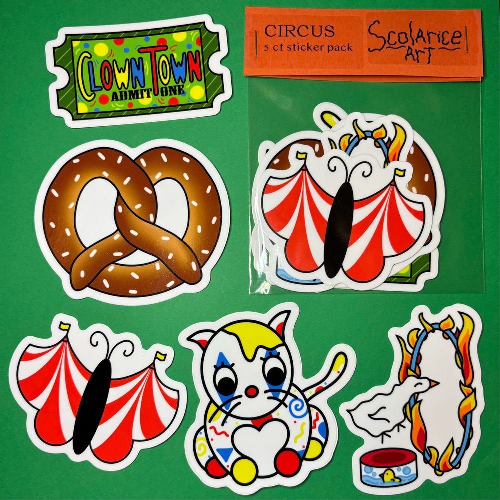 5 hand-drawn cartoon stickers and a sticker pack against a green background. Stickers depict a green ticket that says Clown Town Admit One, a soft pretzel, a butterfly with circus tent wings, a white cat with primary colored shapes and clown makeup, and a white goose jumping through a flame hoop. 