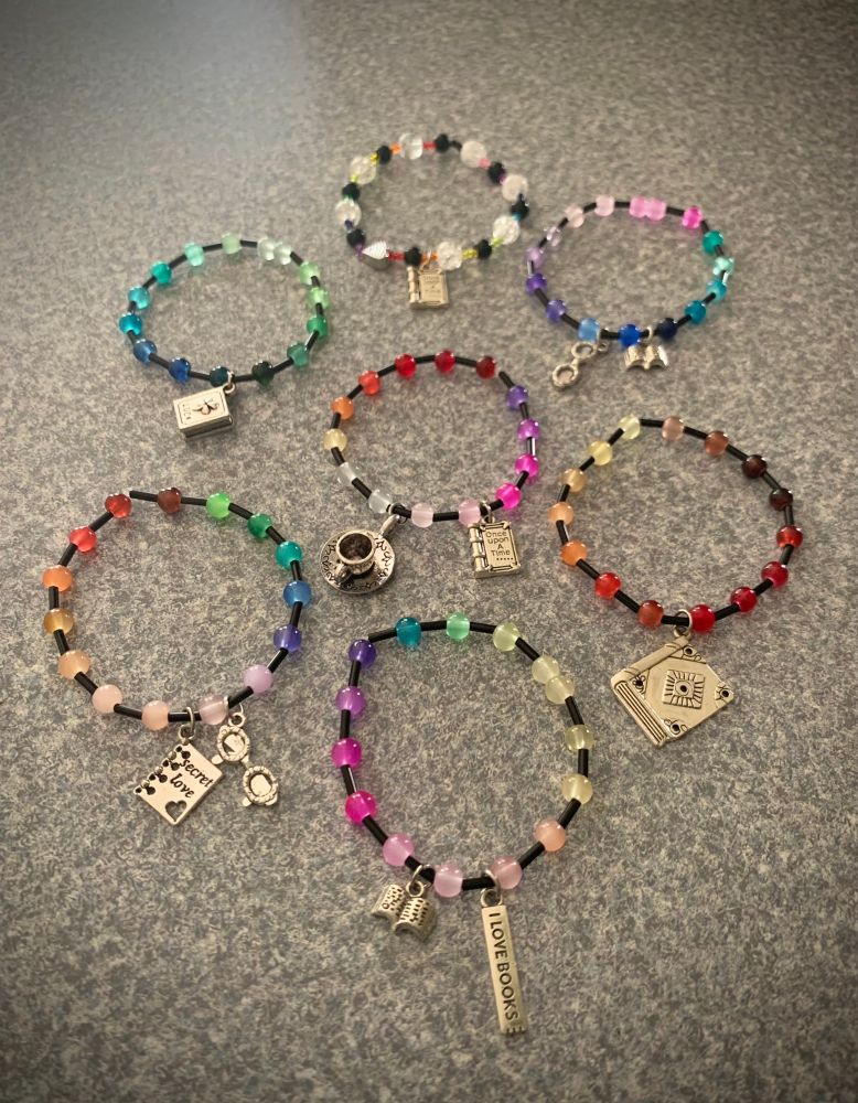 Multicolored glass bracelets with metal book charms 