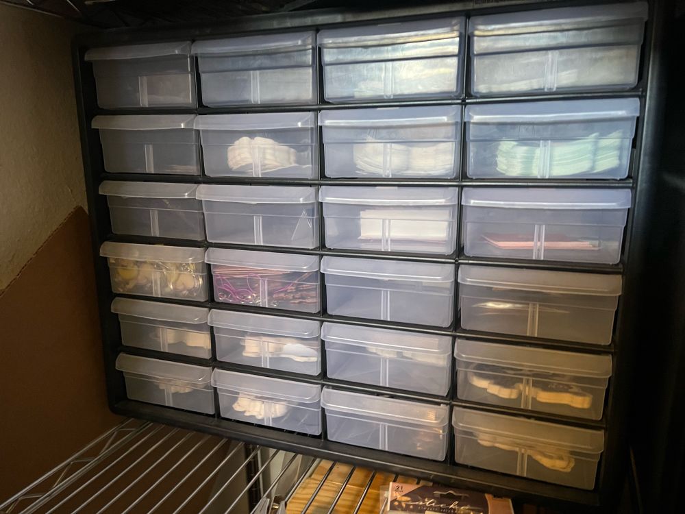 A 24-stack of drawers almost all full of stickers, keychains, and charms