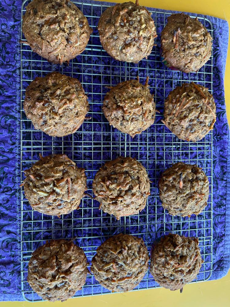 A dozen morning glory muffins cooling on a cooling rack